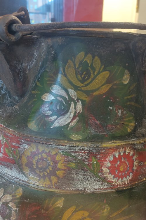 A colourfully decorated water jug in a large glass display case